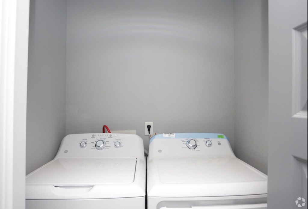 two washers and a dryer in a laundry room