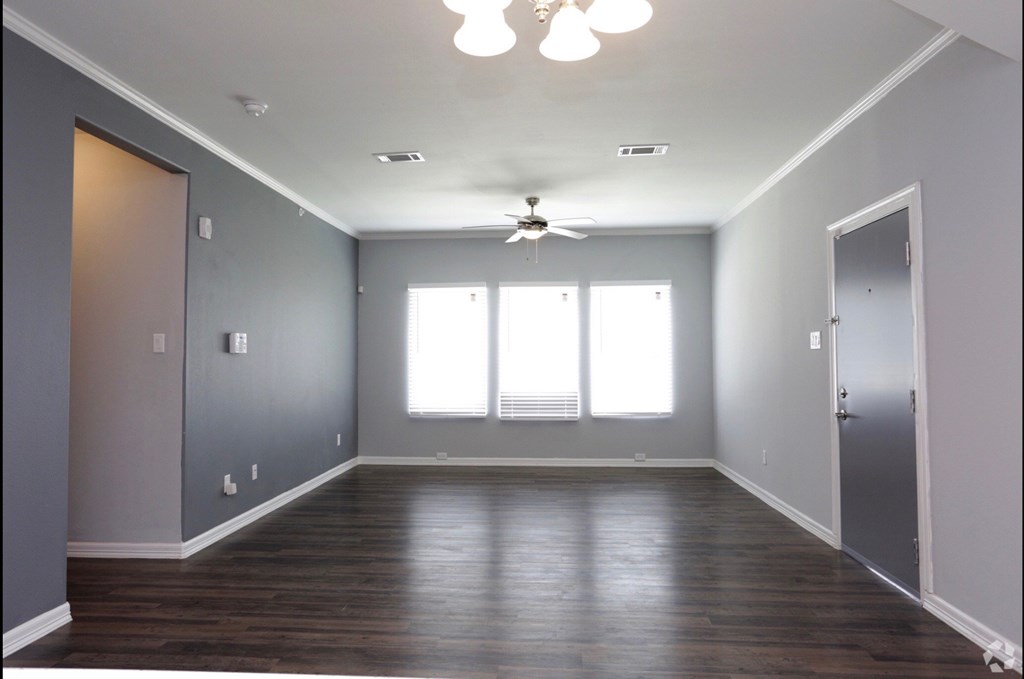 an empty room with wood floors and a ceiling fan