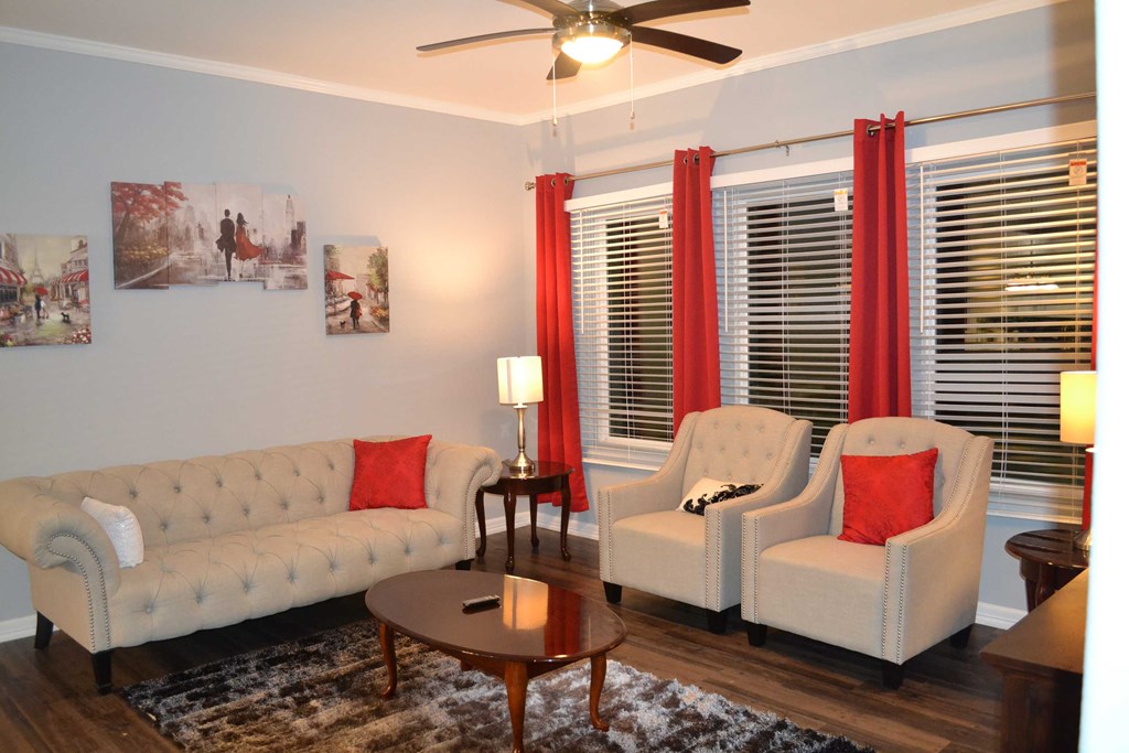 a living room with couches and chairs and a ceiling fan