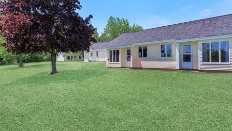 a white house with a yard and a tree