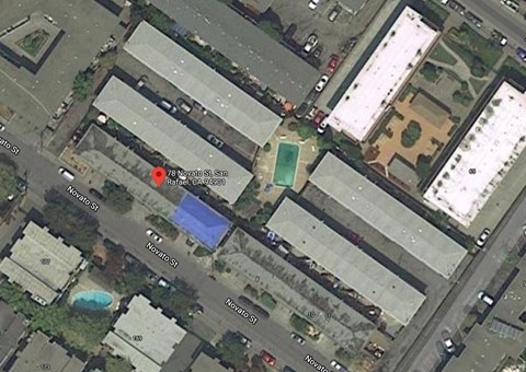 A satellite image shows a street view with a red marker indicating a specific location.