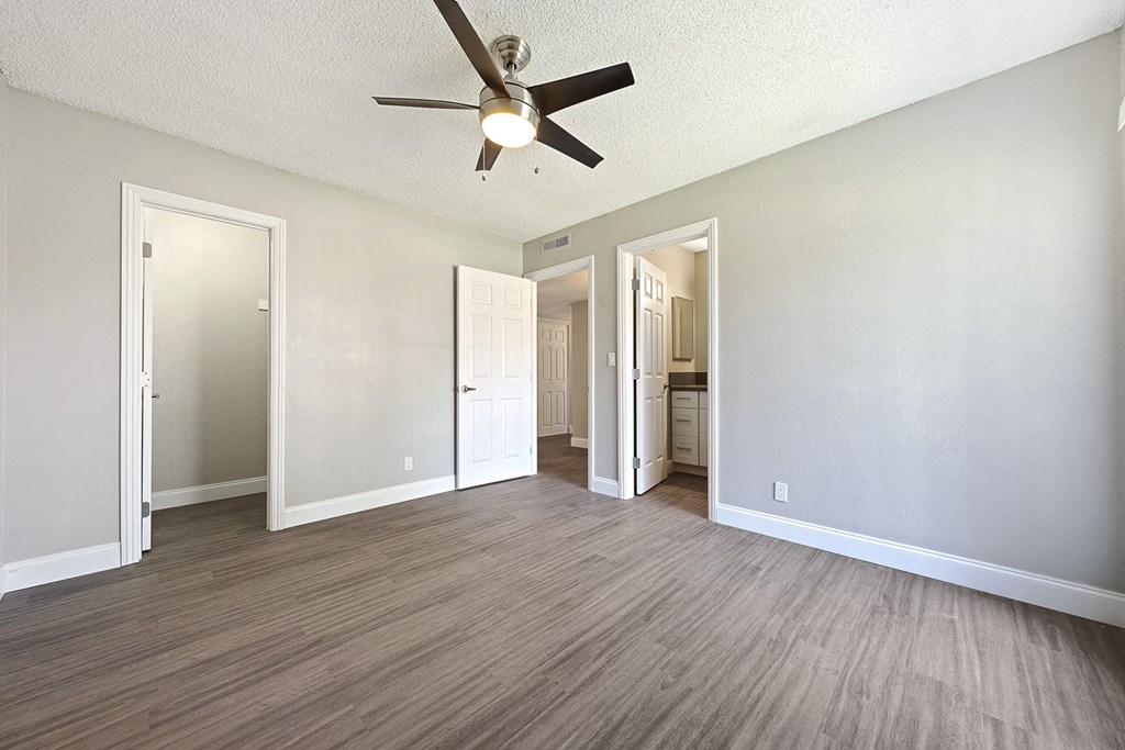 an empty living room with a ceiling fan