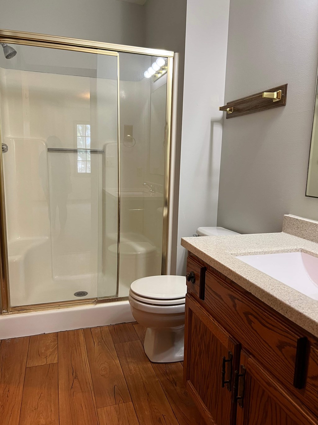 A white toilet sits in a bathroom with a glass shower door.