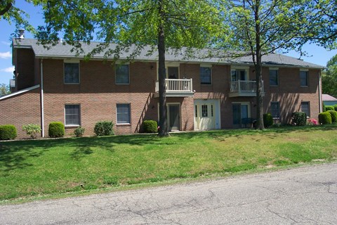 A large brick building with a tree in front of it.
