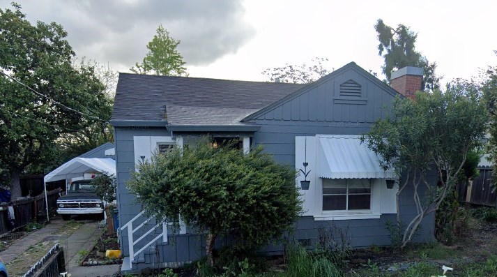 A house with a grey roof and a white awning.