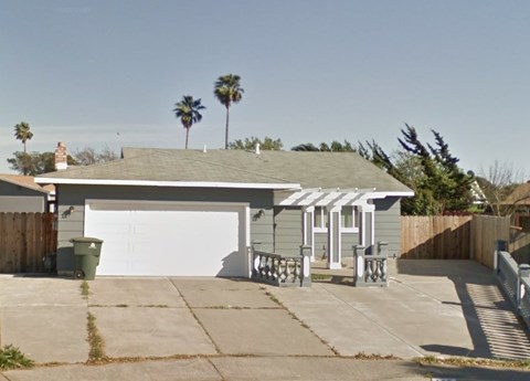 a house with a white garage door and palm trees