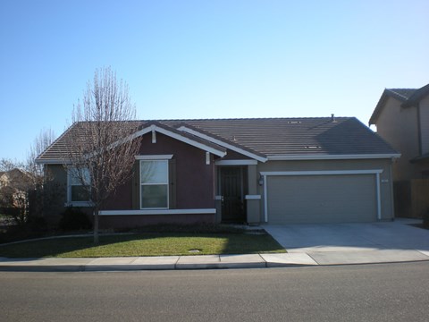 the front of a house with a driveway and a garage door