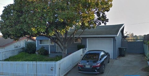 a car parked in a driveway in front of a house