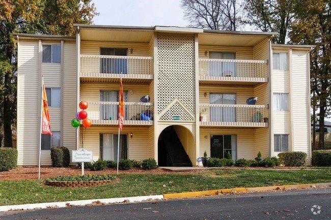 a yellow apartment building with balloons in front of it