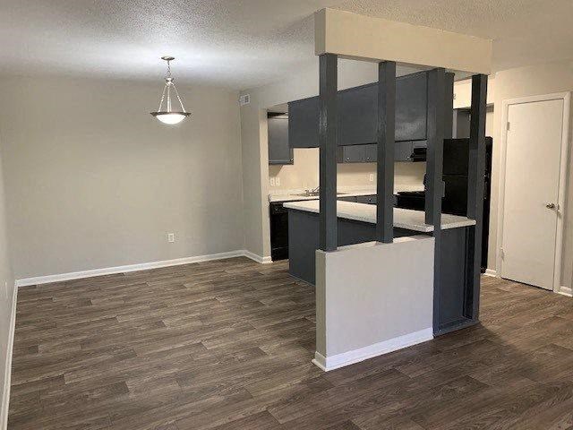 a kitchen and a living room with a wood floor
