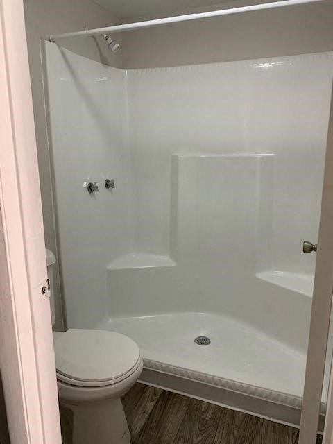 a white bathroom with a shower and a toilet