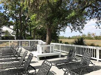a group of chairs sitting on a deck next to a tree