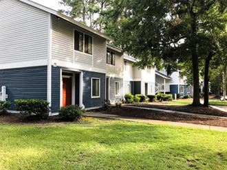 a row of houses with a yard and trees