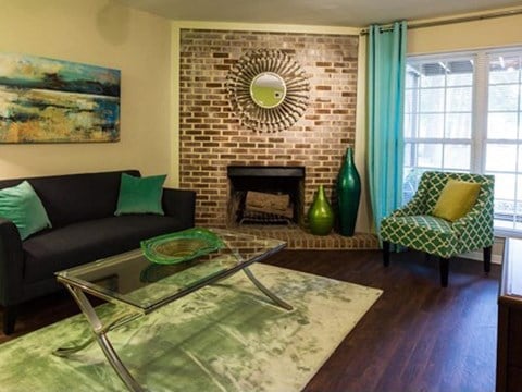 a living room with a couch and a table and a brick fireplace