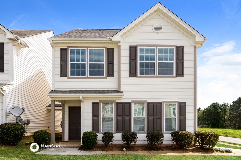 a white house with black shutters and a lawn