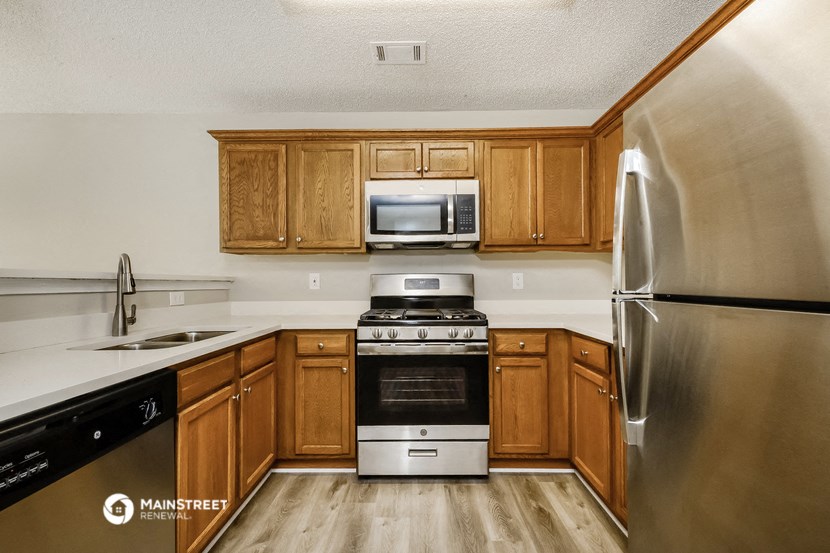 a kitchen with wooden cabinets and stainless steel appliances