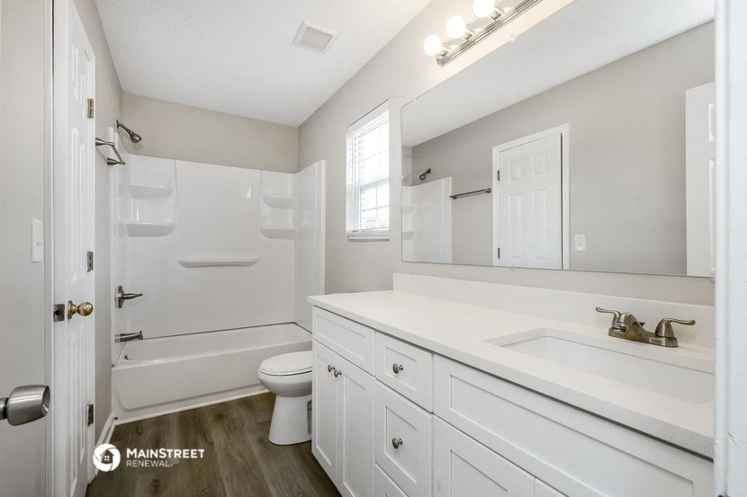 a bathroom with a white sink and a toilet and a shower