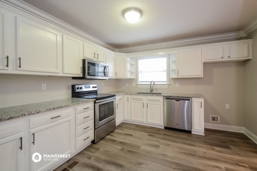 a kitchen with white cabinets and stainless steel appliances