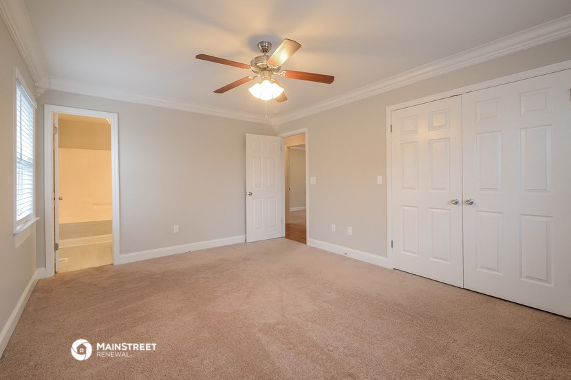the living room of an empty home with a ceiling fan