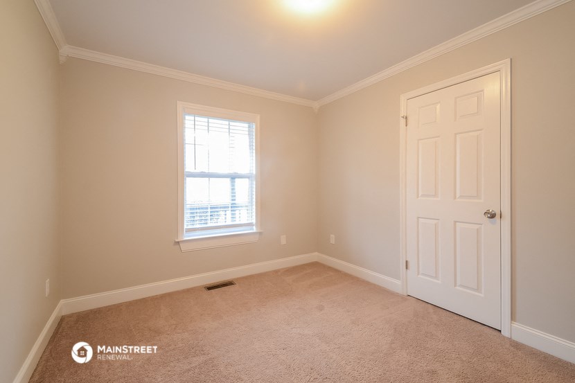 a bedroom with a white door and a window