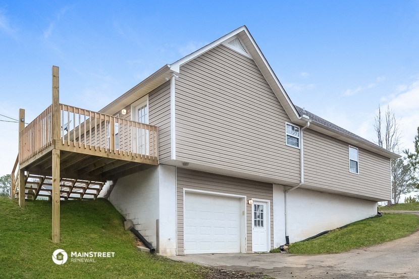 the front of a house with a deck and a garage