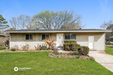 a small white house with a lawn and a white door