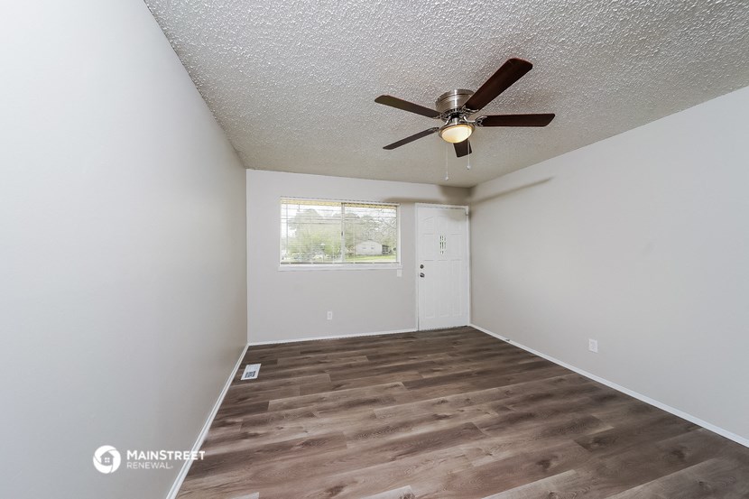 a living room with a ceiling fan and a window
