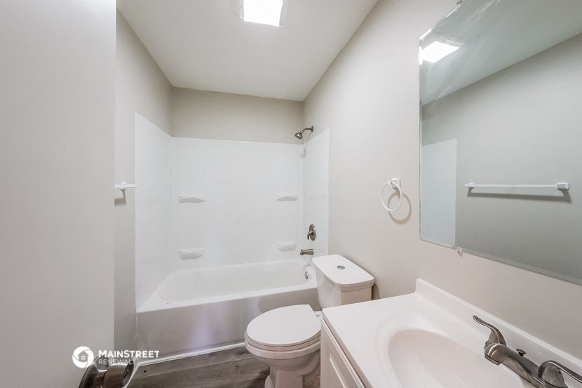 a white bathroom with a white toilet and a tub and a sink