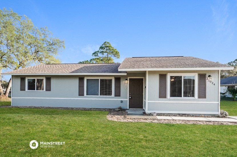 a blue house with a yard and a lawn