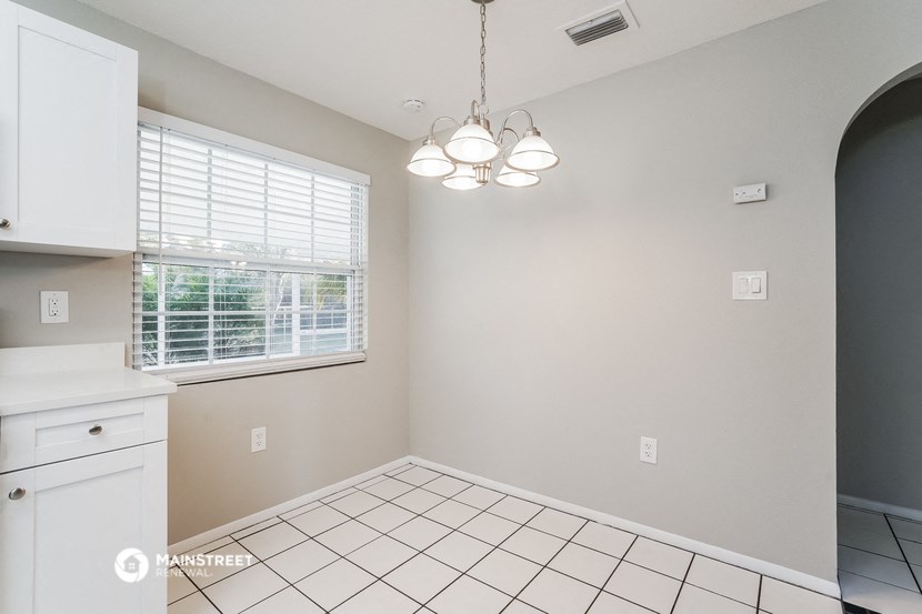 the kitchen and dining room of a house with a tiled floor