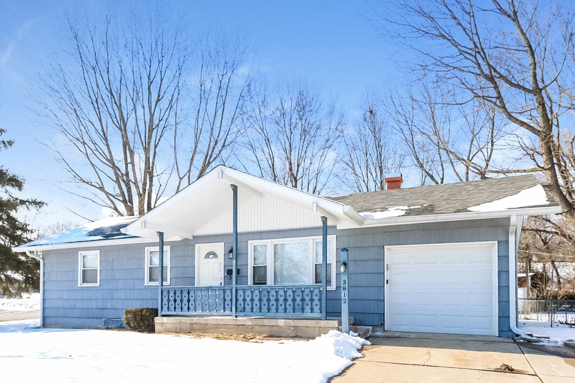 a blue house with a white roof and a white garage door