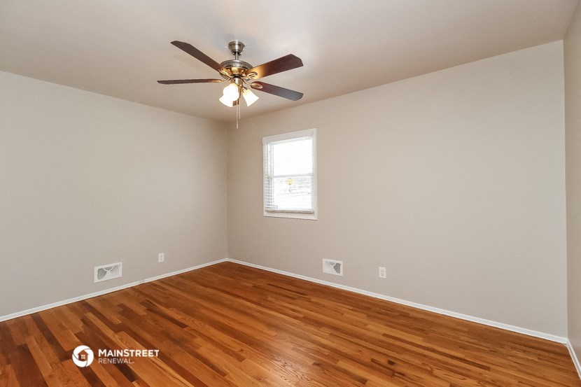 the living room with hardwood floors and a ceiling fan
