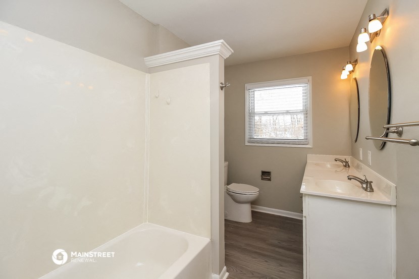 a bathroom with a toilet and a sink and a bath tub