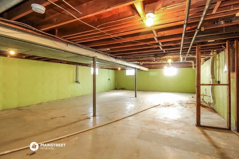 the inside of a garage with green walls and a concrete floor