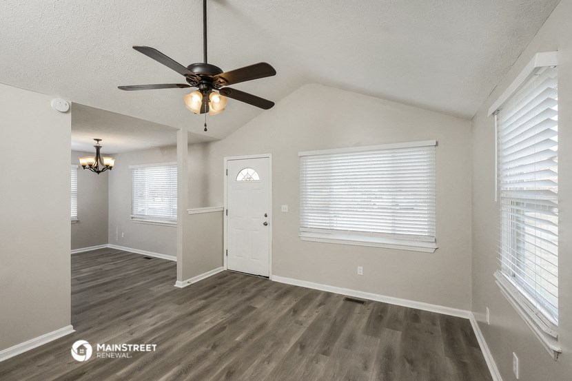 the spacious living room and dining room with a ceiling fan