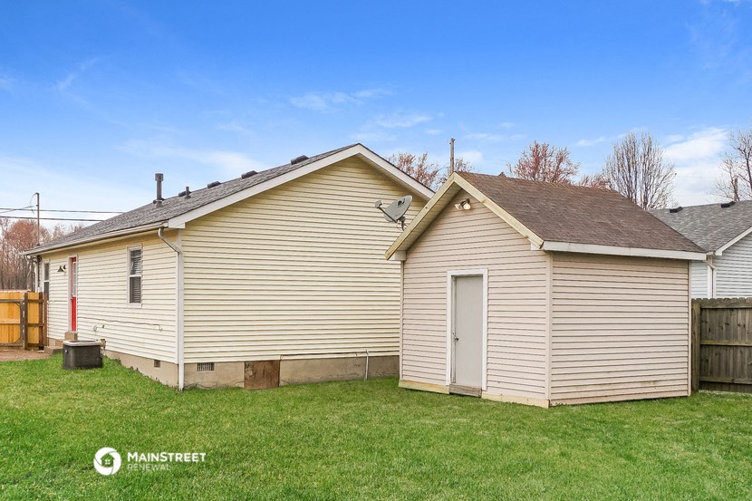 a small house with a garage and a green lawn