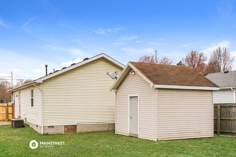 a small house with a garage and a grassy yard