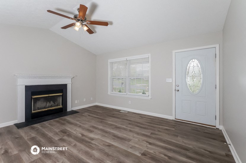 the living room with fireplace and ceiling fan