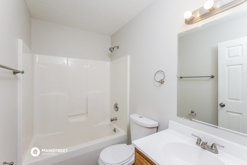 a white bathroom with a white toilet and a tub and a sink