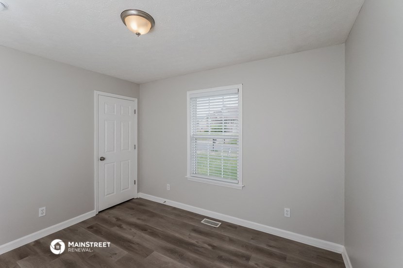 the interior of a bedroom with a door and a window