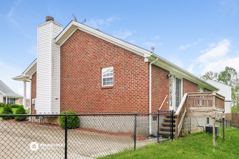 a brick home with a chain link fence in front of it