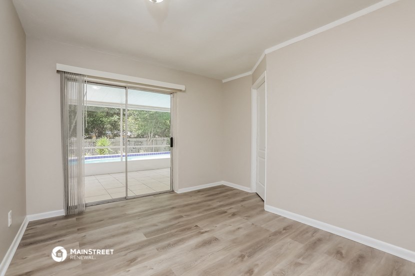 a living room with a sliding glass door to a pool