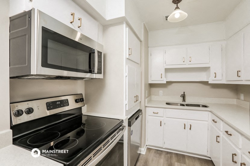 a kitchen with white cabinets and black appliances and a microwave