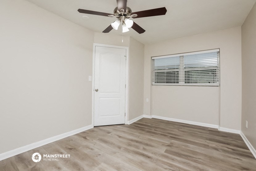 the living room of our studio apartment atrium with ceiling fan and window