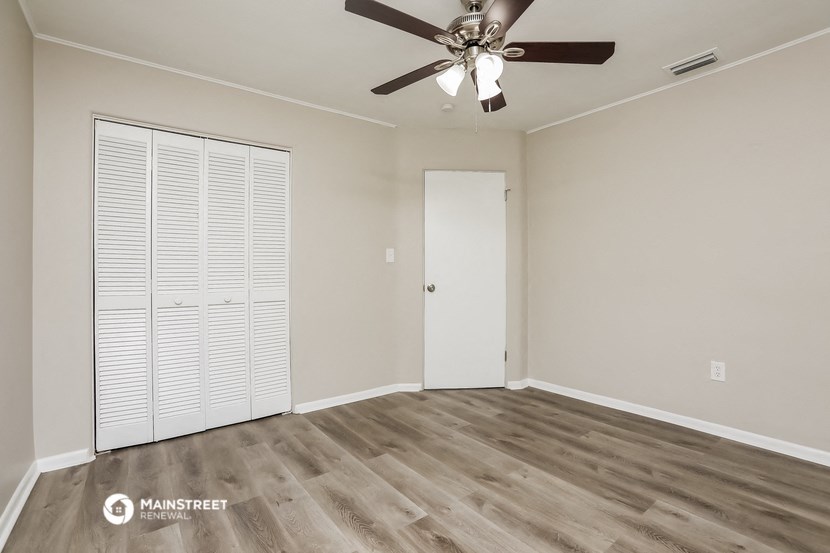 a bedroom with a ceiling fan and a closet