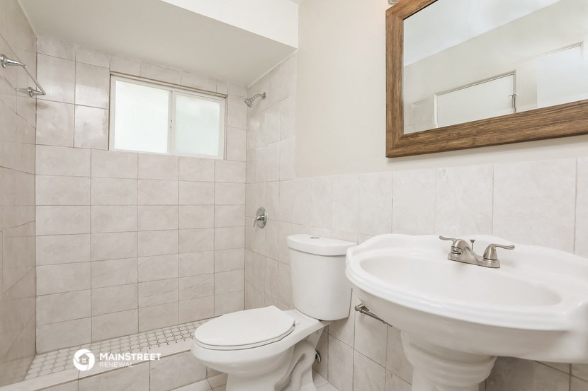 a bathroom with a toilet and a sink and a mirror