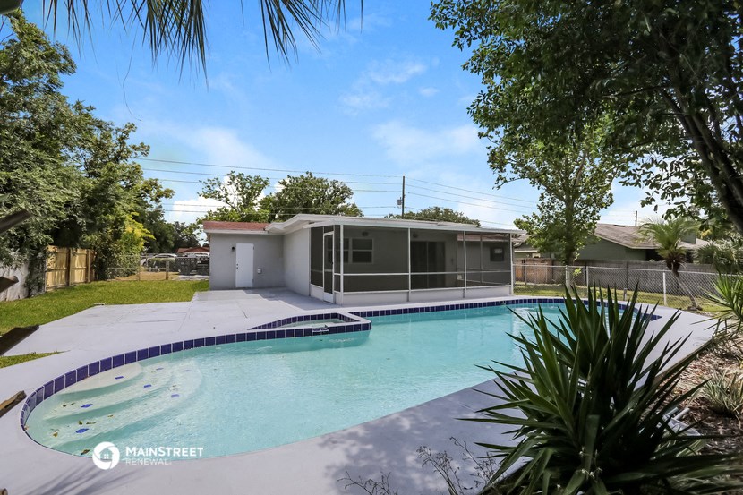 a swimming pool and a house in a yard with a pool