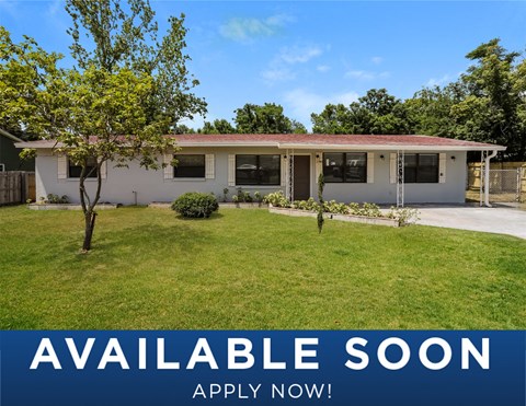 a small white house with a yard and grass