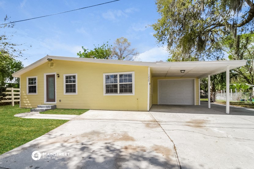 a yellow house with a driveway and a white garage door