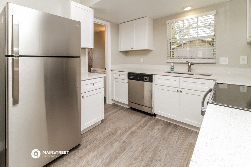 a renovated kitchen with white cabinets and stainless steel appliances